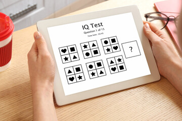 Woman using tablet for taking IQ test indoors, closeup - obrazy, fototapety, plakaty
