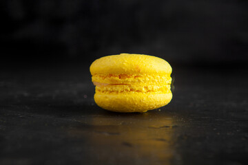 colored fresh macarons in studio on black background
