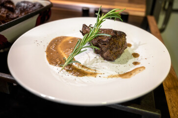 Close-up view of a white plate with roasted beef fillet. Young beef with spices and sauce, beautifully arranged and ready to serve.