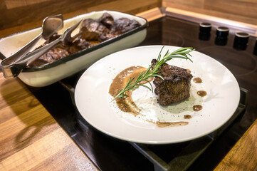 Close-up view of a white plate with roasted beef fillet. Young beef with spices and sauce, beautifully arranged and ready to serve.
