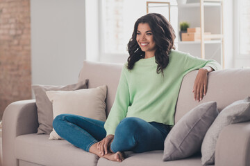 Obraz premium Portrait of attractive cheerful girl sitting on divan staying home watching movie film in flat apartment indoor