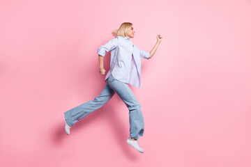 Full size profile photo of energetic girl look empty space running hurry isolated on pink color background