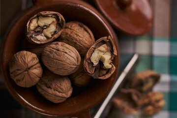 Open and closed walnuts inside an old stewpan in the kitchen. Close up on walnuts