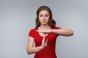 Young nice brunette woman doing time out gesture with hands, frustrated and serious face