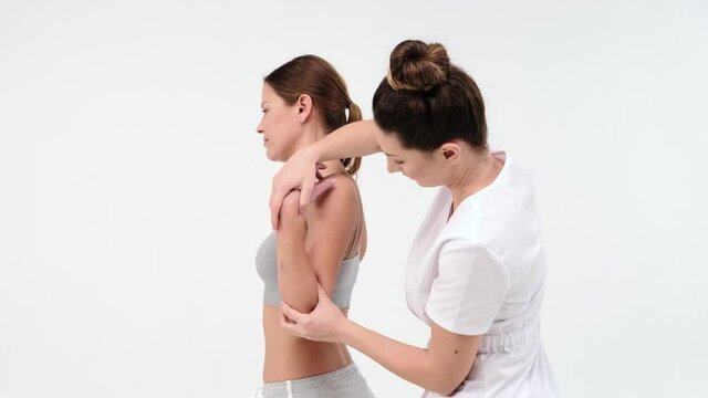 A Modern rehabilitation physiotherapy worker with woman client. chiropractor massaging femail shoulder