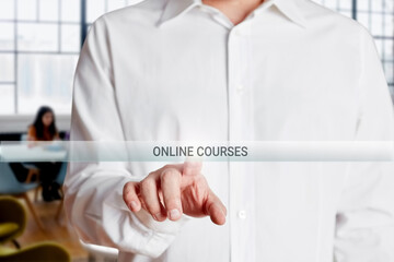Male hand presses online courses button on a virtual touch screen.