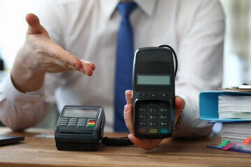 Male consultant demonstrates payment terminal for plastic cards