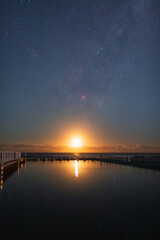 Moonrise view over beach horizon.