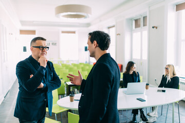 Business men discussing together in an office in front of team