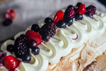 Meringue roll with berries. Delicious meringue roll on the table 
