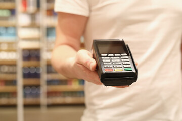 Man hand holds bank payment terminal closeup