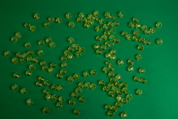 Green plastic beads on a green background.