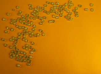 Green plastic beads on a yellow background.