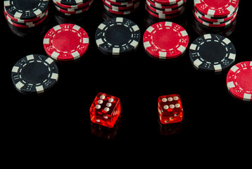 Poker dice with maximum winning combination of twelve on black table and chips in the background