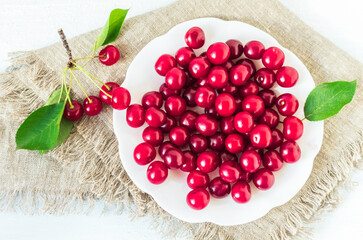 Sweet cherry in a plate close up on a white background. Top view.