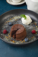 Chocolate fondant with vanilla ice cream and berries. Restaurant serving