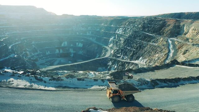 Open pit with machines riding around it. Mining industry concept.