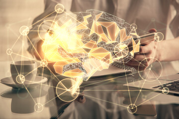 Double exposure of brain sketch hologram and woman holding and using a mobile device.