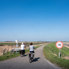 people ride bicycle on sunny spring day in dutch countryside of zeeland