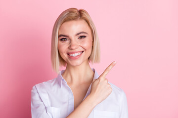 Photo of positive happy young woman smile point finger empty space promoter isolated on pastel pink color background