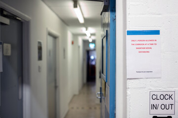 A social distancing sign in a workplace advising that only 1 person is allowed in the corridor at a time. Social distancing, safety, new normal, workplace concept