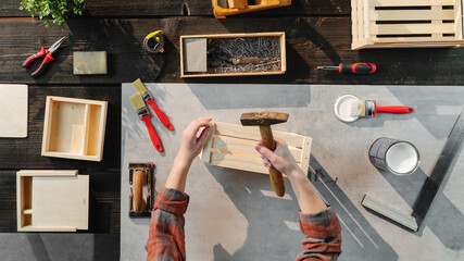 Top view of unrecognizable woman making wooden boxes, small business and desktop concept.