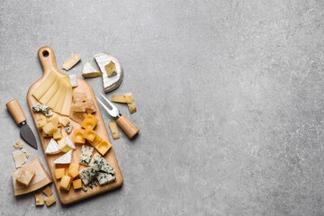 Cheese plate and cutlery on grey table, flat lay. Space for text