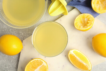 Freshly squeezed lemon juice on grey table, flat lay