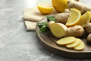 Fresh lemon and ginger on grey marble table, closeup. Space for text