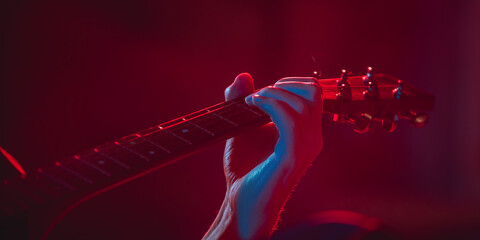 Close-up of musician performing in neon light. Concept of advertising, hobby, music, festival, entertainment.