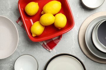 Obraz na płótnie Canvas Set of ceramic dishware and fresh lemons on grey marble table, flat lay