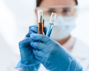 close up. female scientist marks tubes with tests.