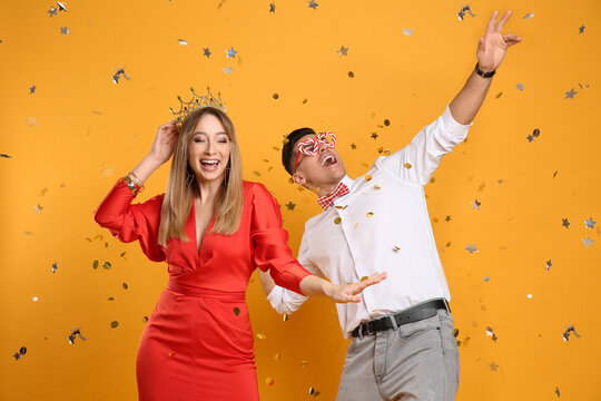 Happy couple and confetti on yellow background - Powered by Adobe