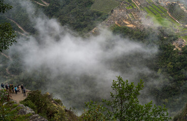 view from the mountain to the path and ancient ruins below the clouds 