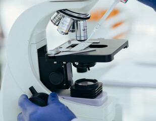 close up. scientist using an automatic dispenser during his research