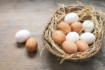 Basket in eggs on wooden background.	