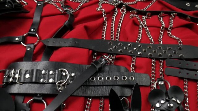 A set of erotic toys for BDSM. Sex slavery game with whip, gag and leather face mask. Intimate sex games leather belts