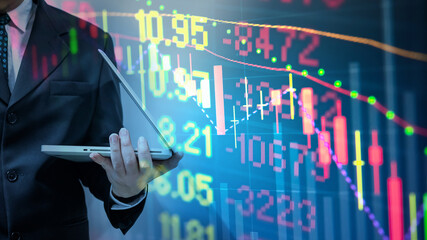 Double exposure of young business man and digital number of stock market background to represent...