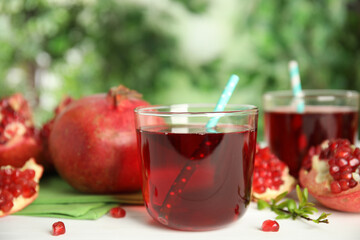 Pomegranate juice and fresh fruits on white table outdoors