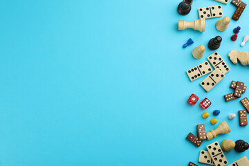 Components of board games on light blue background, flat lay. Space for text