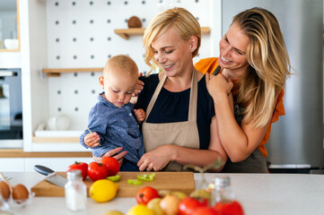 Happy lesbian female couple with her little child at home