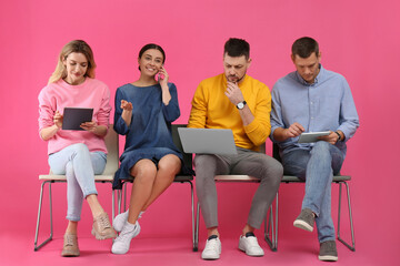 People waiting for job interview on pink background