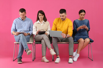 People waiting for job interview on pink background