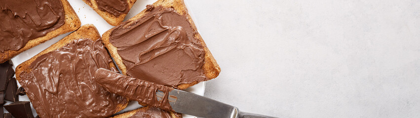 Toast with chocolate-nut paste spread top view with copy space banner