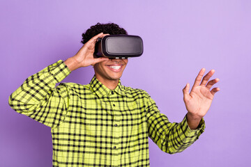 Photo portrait of guy wearing virtual reality glasses smiling in casual clothes isolated on pastel purple color background
