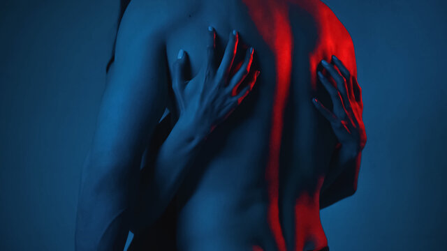 cropped view of woman scratching back of shirtless man on blue