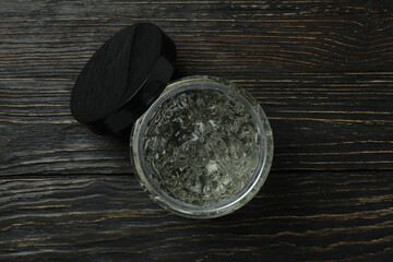 Jar of styling gel on wooden table