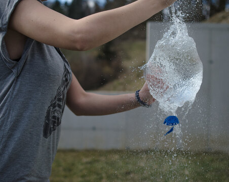 Girl Puncturing A Water Ballon Freeze-frame Shot