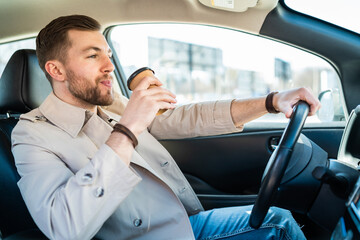 Man drinking morning coffee while driving car