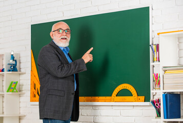 university courses. stem in classroom. senior man teacher use tool at blackboard. bearded tutor in...